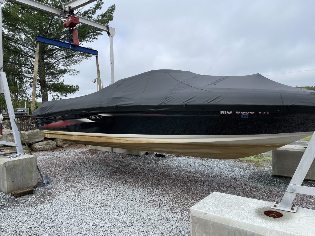 Boat suspended in air being prepared for winter and summer services