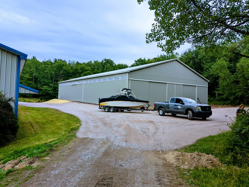 Boat on trailer being towed by pickup truck for transportation service