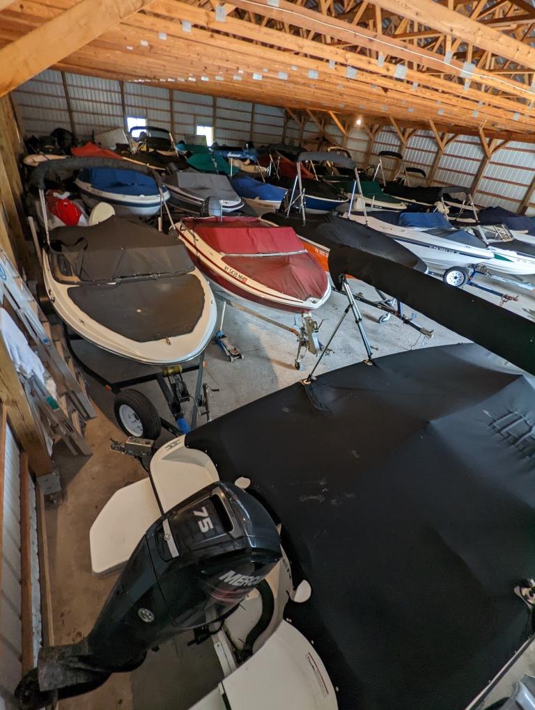 Indoor and outdoor boat storage with multiple boats in warehouse at New Wave Marina